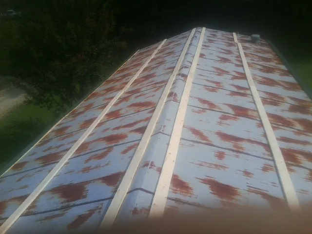 Rusted metal roof panels with new wood purlins before replacement — Storm Damage Roof Repair in Keuka Park by Roofing Brothers