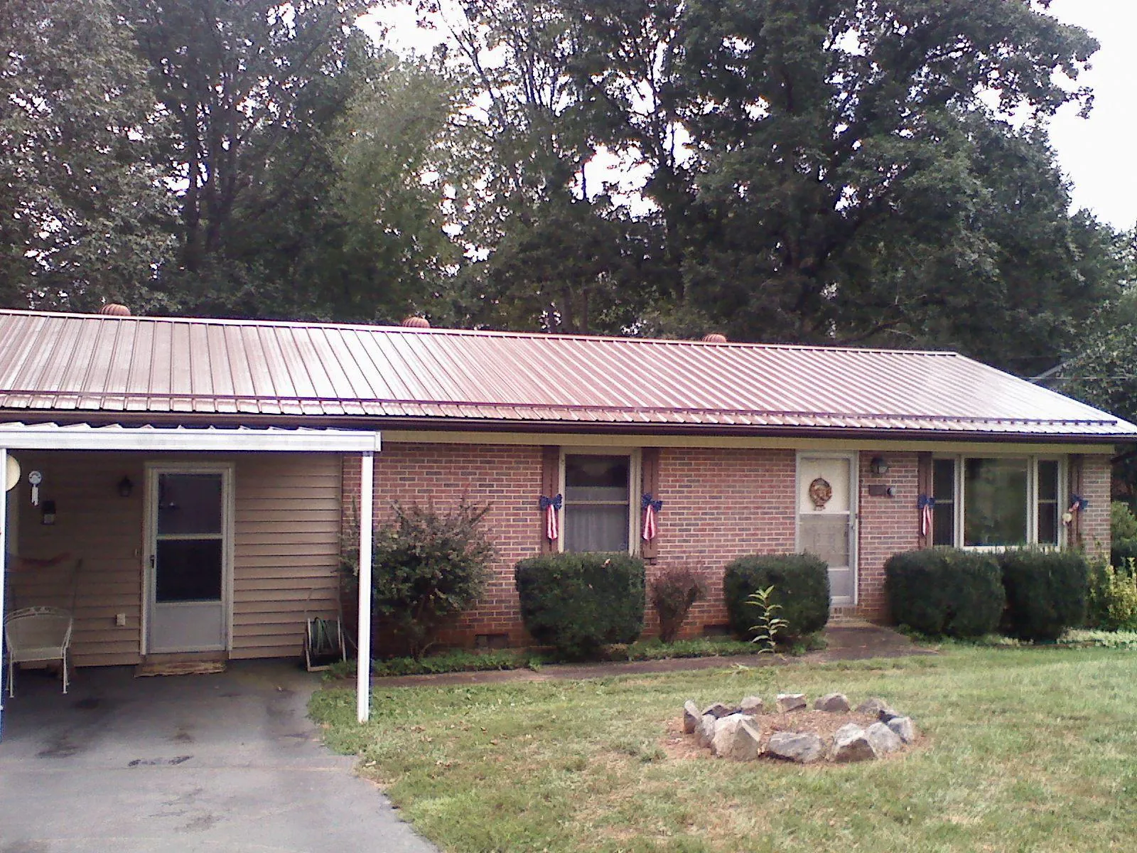 Bronze metal roof and carport on a brick ranch home — Roof Repair work by our crew in Keuka Park